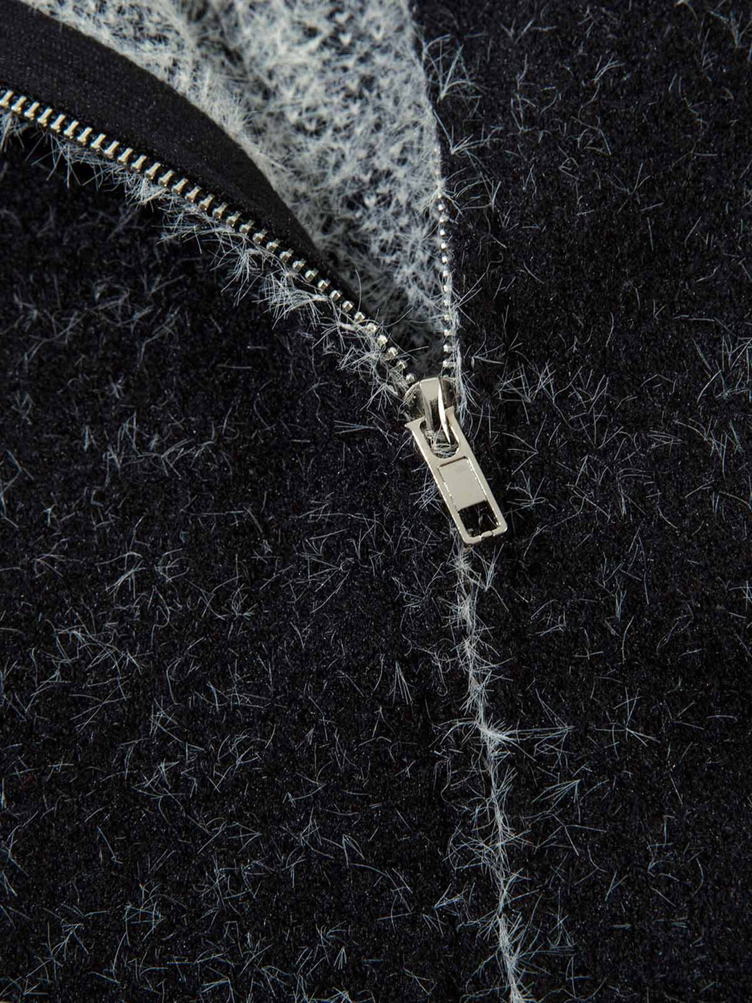 Close-up of a zipper on a textured black fabric background